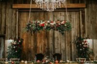 a fantastic fall rustic wedding reception with lots of pumpkins on the floor, bold blooms and neutral ones, greenery and colorful ribbons