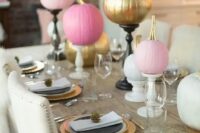 a glam fall wedding tablescape with pink and gold pumpkins as vases, elegant place settings and tiny pinecones