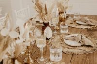 a neutral boho wedding tablescape with dried fronds and blooms, jute placemats and ribbed glasses will be great for a neutral fall wedding
