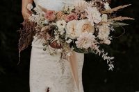 a neutral fall wedding bouquet with blush, creamy and burgundy blooms and leaves plus some grasses