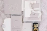 a refined minimalist wedding invitation suite in grey and white, with black lettering and white ribbons and stamps is cool