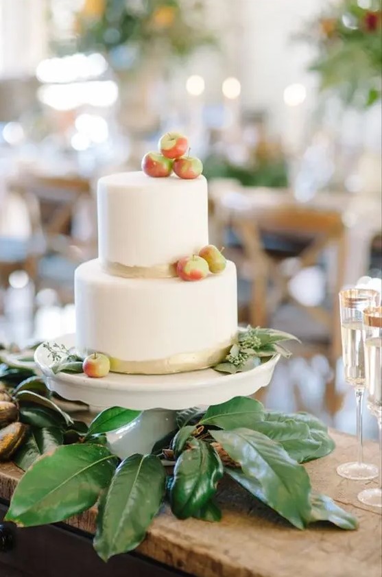 a simple modern fall wedding cake with gold touches and fresh apples and euclayptus is a very cool and beautiful idea