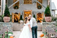 a simple rustic wedding aisle lined up with pumpkins, with bold leaves is a cool idea for a modern rustic space