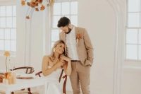 a tan checked pantsuit, a white shirt, brown boots and a bold boutonniere are a cool combo for a boho groom’s look