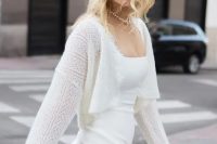 a very delicate cropped crochet bridal cardigan paired with a plain wedding dress for a simple and modern bridal look
