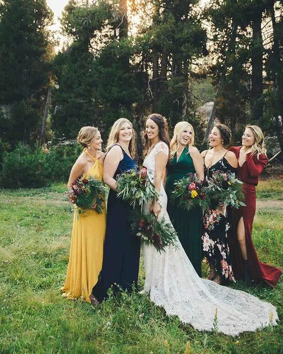 amazing mismatching bridesmaid dresses - a yellow, navy, emerald, burgundy and black floral one for a bright fall wedding