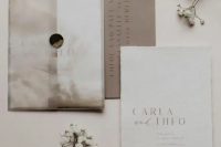 an elegant wedding invitation suite with a neutral envelope, a white and a taupe card plus letter pressing