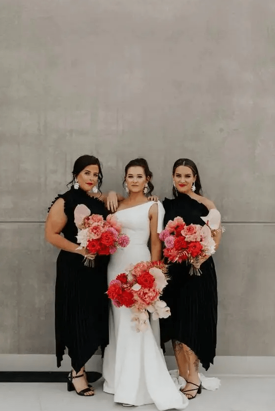 beautiful and sophisticated black one shoulder midi bridesmaid dresses with asymmetrical skirts, black shoes and statement white earrings