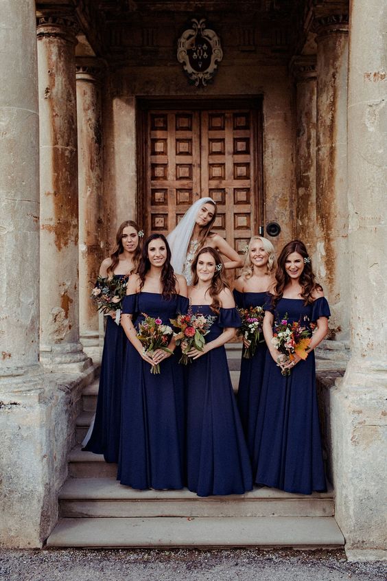 chic off the shoulder navy maxi bridesmaid dresses with pleated skirts are a cool idea for a bold fall wedding
