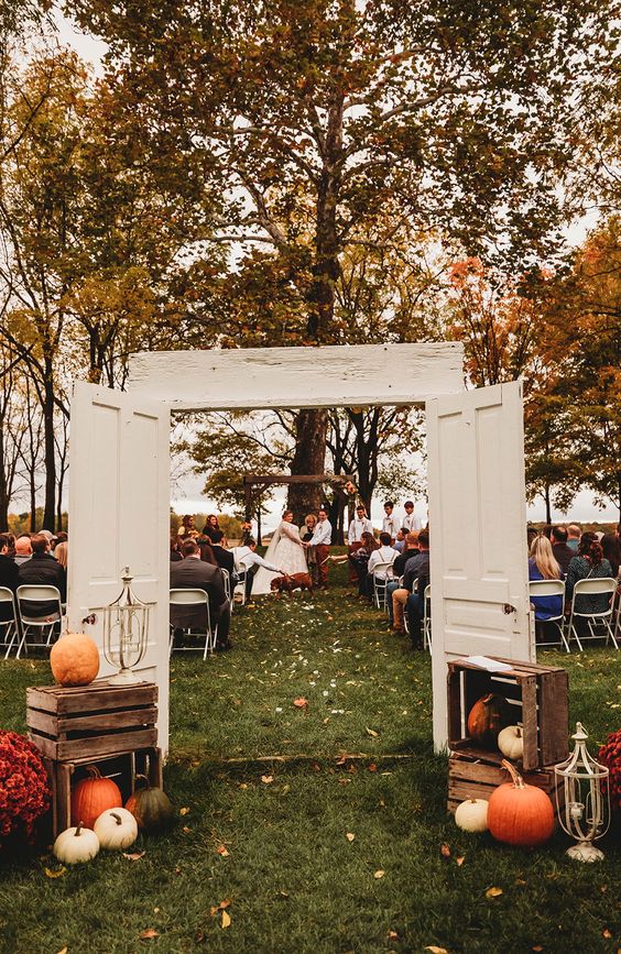 fall wedding decor with crates, pumpkins and bold blooms is a cool idea for an indoor or outdoor wedding