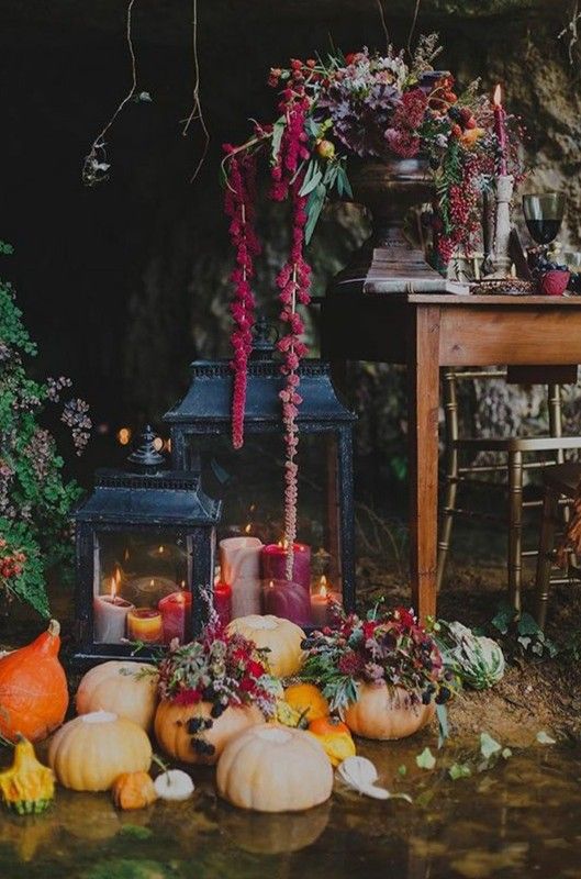fall wedding decor with large candle lanterns and pumpkins with blooms and candles is very chic and very refined