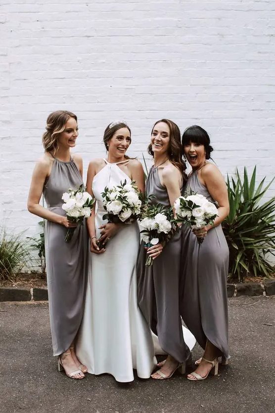 grey midi bridesmaid dresses with halter necklines and draped bodices and silver shoes for a stylsh and elegant wedding