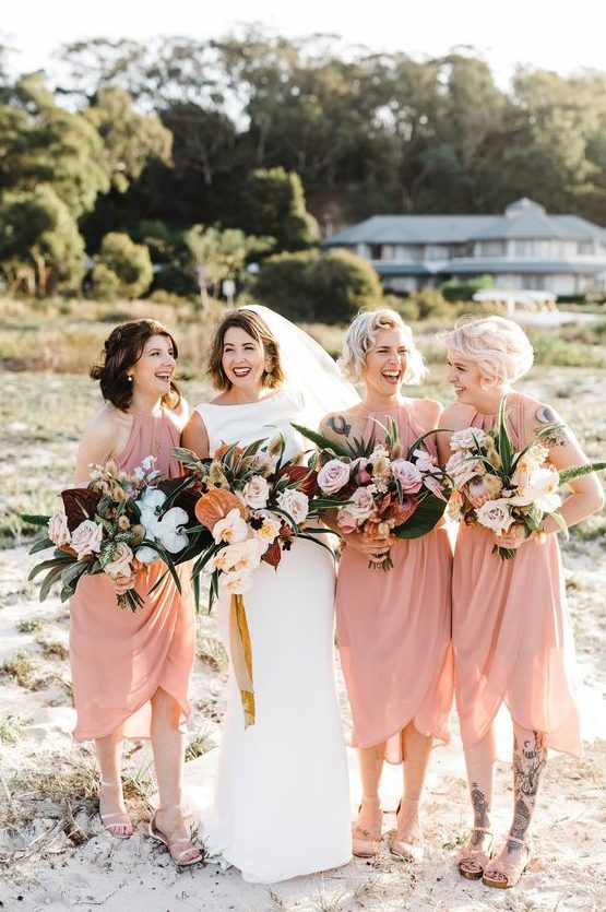 matching light pink midi wrap bridesmaid dresses with drapery and comfy sandals for a tropical wedding