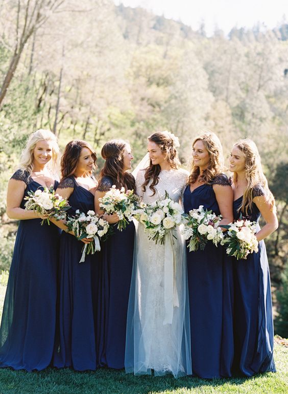 maxi navy bridesmaid dresses with lace cap sleeves and V-necklines, draped bodices for an elegant and timeless wedding