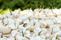 miniature ghost pumpkins can be used as cute little favors and to display escort cards at the same time