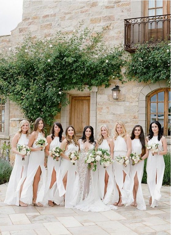 minimalist white halter neckline maxi bridesmaid dresses with front slits are a cool and breezy idea for spring or summer weddings