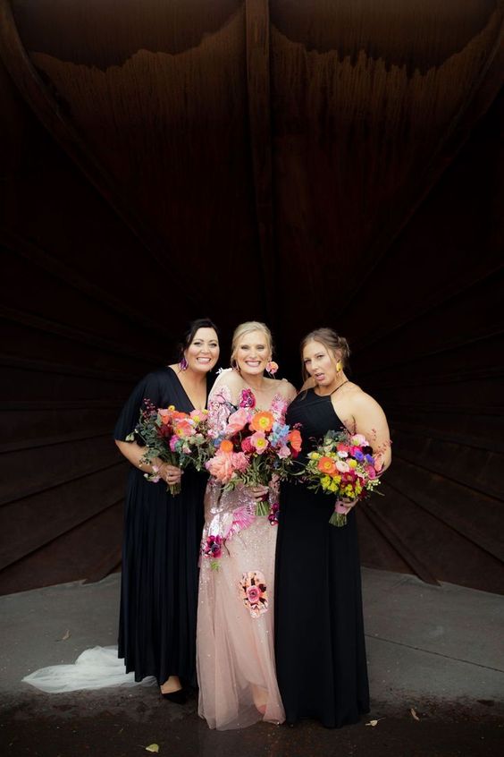 mismatched black maxi bridesmaid dresses with a V and halter neckline and pleated skirts for a bold wedding