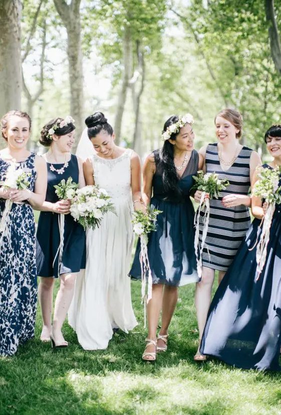 mismatching nautical bridesmaid dresses in navy and white with a fitting knee dress with no sleeves and a deep neckline