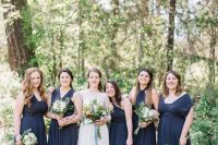 mismatching navy maxi bridesmaid dresses with pleated skirts and draped bodices for an elegant and refined wedding
