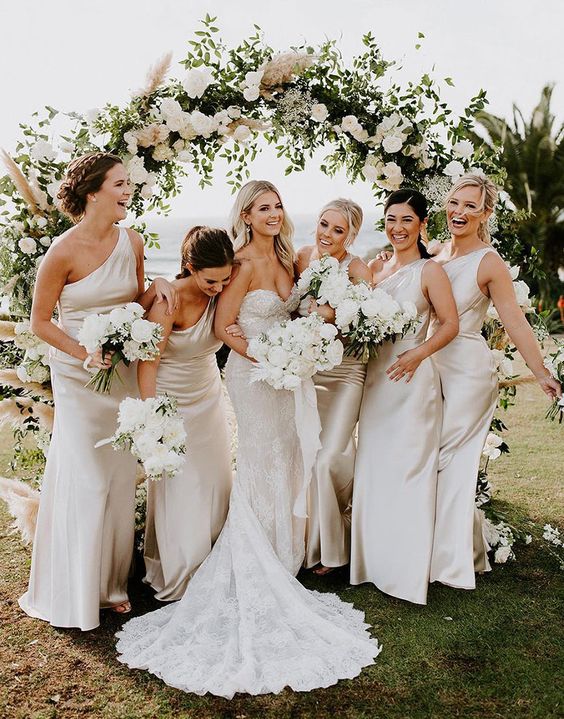 one shoulder ivory satin maxi bridesmaid dresses are a cool idea for a neutral spring or summer wedding