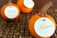 orange pumpkins with glitter stems and cards on them are sure to make your wedding cuter and lovelier