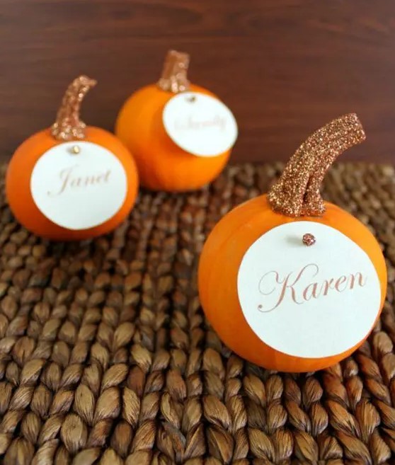 orange pumpkins with glitter stems and cards on them are sure to make your wedding cuter and lovelier
