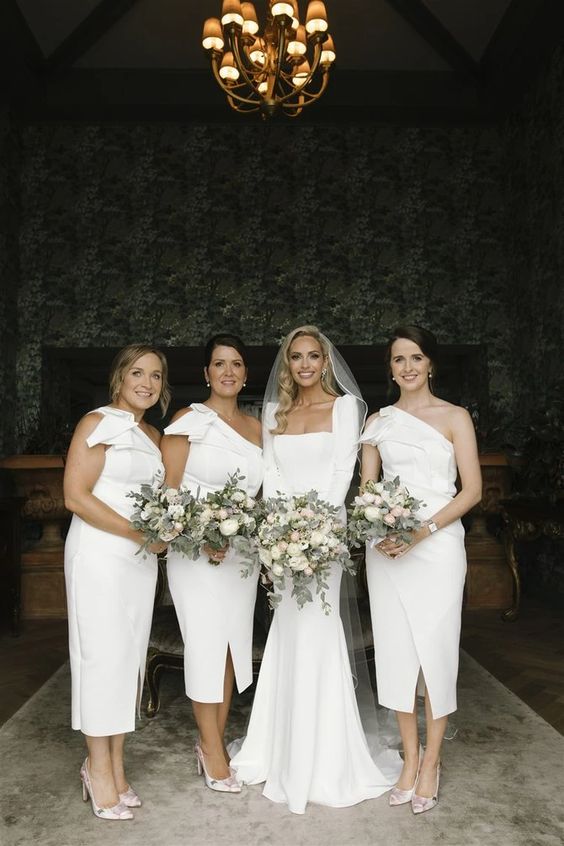 pretty white one shoulder midi bridesmaid dresses with slits and textural details on the shoulder, floral shoes are cool