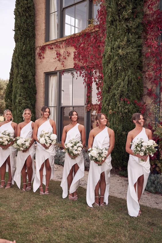 stylish white one shoulder high low bridesmaid dresses are a cool solution for a modern summer wedding