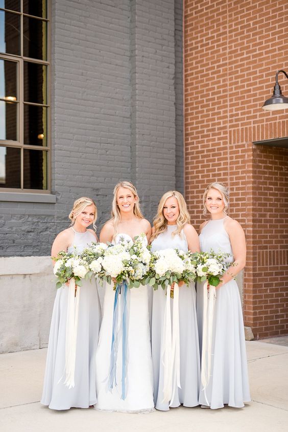 very pale blue maxi bridesmaid dresses with halter and strapless necklines and pleated skirts are lovely for a spring wedding