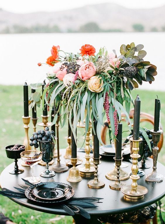 black candles, feathers and dishes add an ambience to this tablescape