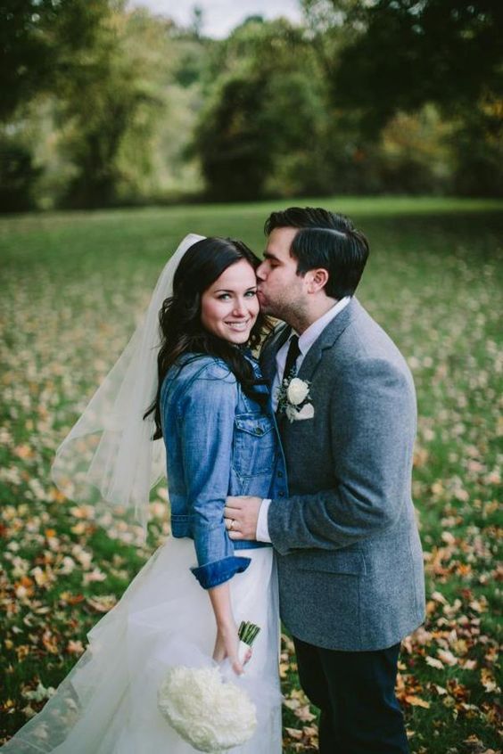 a blue denim jacket over a romantic tulle wedding dress is a gorgeous idea for a modern bride who loves everything casual and boho