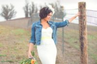 a barn wedding outfit with a lace mermaid strapless wedding dress and a blue denim jacket plus a yellow sash