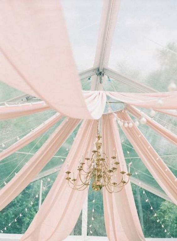 blush fabric and a gold chandelier for tent decor