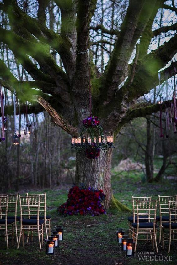 moody florals on the tree and chandelier make the ceremony spot chic