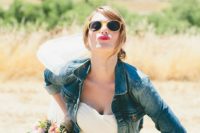 a cropped blue denim jacket as a cover up over a strapless wedding dress for a modern bride
