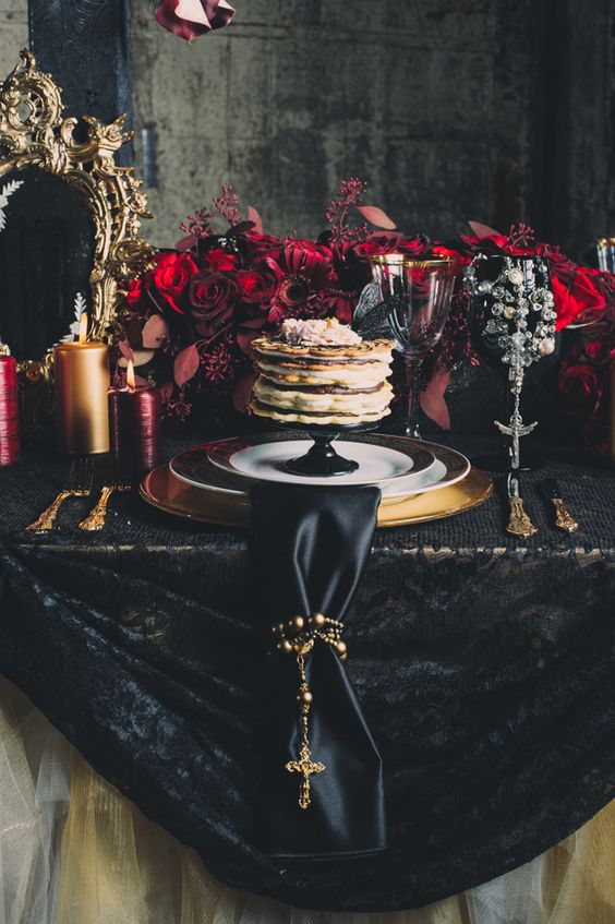 deep red florals, black lace tablecloth and a black napkin are perfect for a gothic wedding.