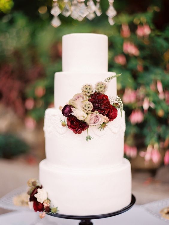 tiered whiite cake with burgundy and blush florals
