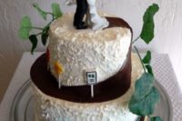 Two tiered wedding cake with small motorcycle statuette