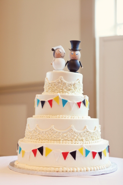White four tiered cake with cute cake toppers