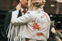 a beautiful boho chic bridal look with a white boho lace wedding dress, a white leather jacket with painting and fringe