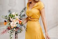 a beautiful gold yellow maxi dress with short sleeves, a V-neckline and a tied detail on the waist