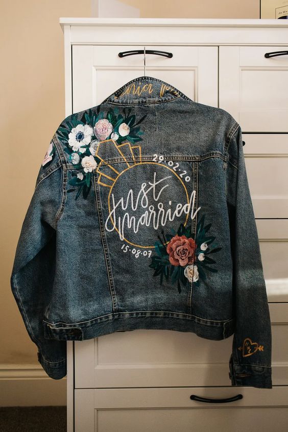 a bleached blue denim jacket with handpainting and colorful embroidery is a lovely idea for a boho bride