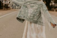 a bleached denim jacket with calligraphy and crystals and pearls, long crystal fringe on the sleeves is amazing