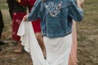 a blue denim bridal jacket with white calligraphy and colorful embroidered blooms is a chic cover up customized for the wedding