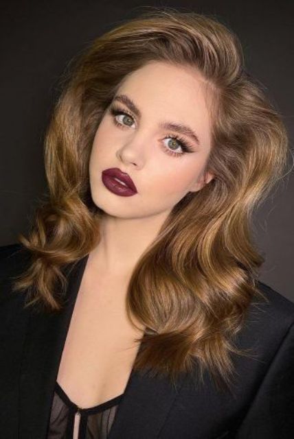 a bold wedding makeup with a dark lip, eyelash extensions and a bit of blush is chic and cool for a winter wedding
