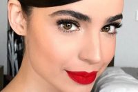 a bold winter wedding makeup with a perfect red lip, eyelash extensions, bushy eyebrows and a touch of shine