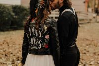 a chic bridal look with a neutral wedding dress, a black leather painted jacket and a bold floral crown is wow