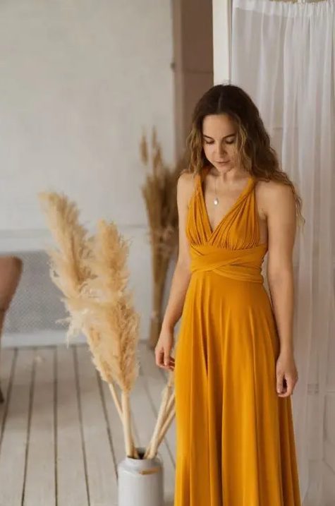 a cool honey yellow maxi bridesmaid dress with a daped bodice and tied waist for a boho wedding