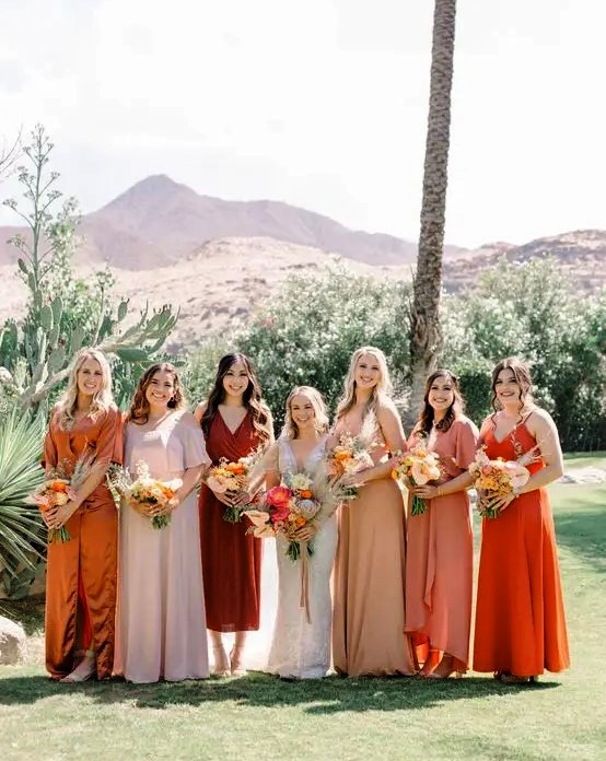 a mismatching bridal party look with blush, light pink, beige and orange maxi dresses for a summer or fall wedding