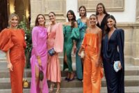a mismatching bridal party look with orange, pink, black, navy, green and blue maxi and midi bridesmaid dresses